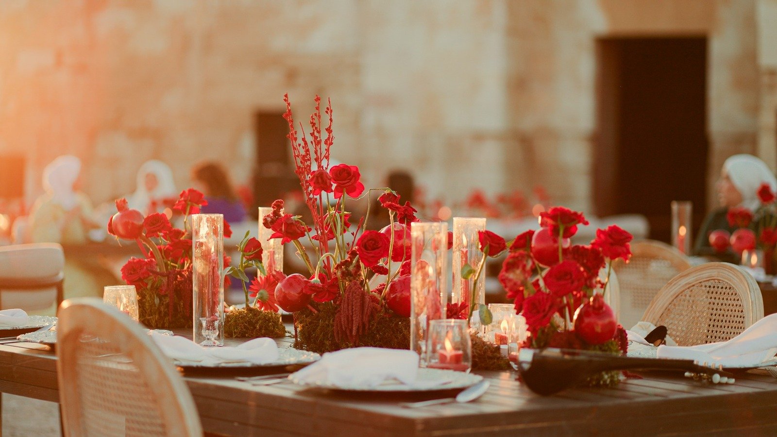 Table decorated with red flowers and candles for luxury dinner