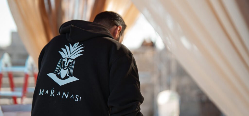 Event crew member in branded hoodie walking through draped venue